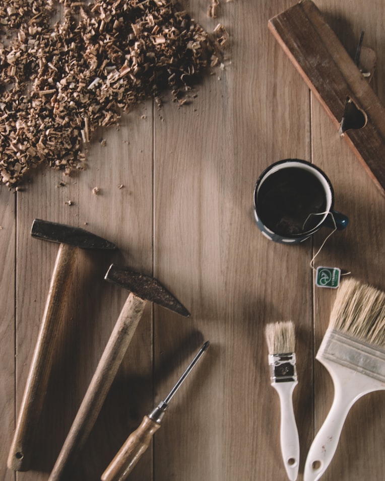 Woodworking tools and fresh shavings arranged on a workshop bench